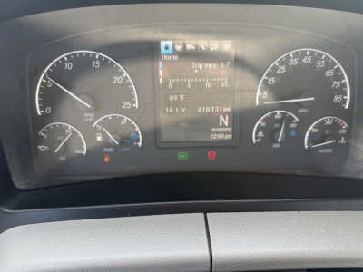 Dashboard of a Freightliner PT126064S T showing  speedometer, tachometer, fuel gauge, engine indicators, and a central display with trip information.