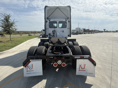 Truck rear view showing fifth-wheel connection and dual rear axles on 2021 Freightliner PT126064S T conventional daycab. Visible mud flaps with Brown National Lease logos, taillights, and highway in background.