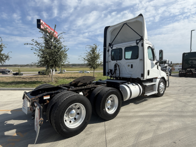 Truck chassis and cab of a Freightliner PT126064S T tractor. Rear view shows dual rear axles, fifth wheel area, exposed fuel tanks, and white cab with open sleeper area.