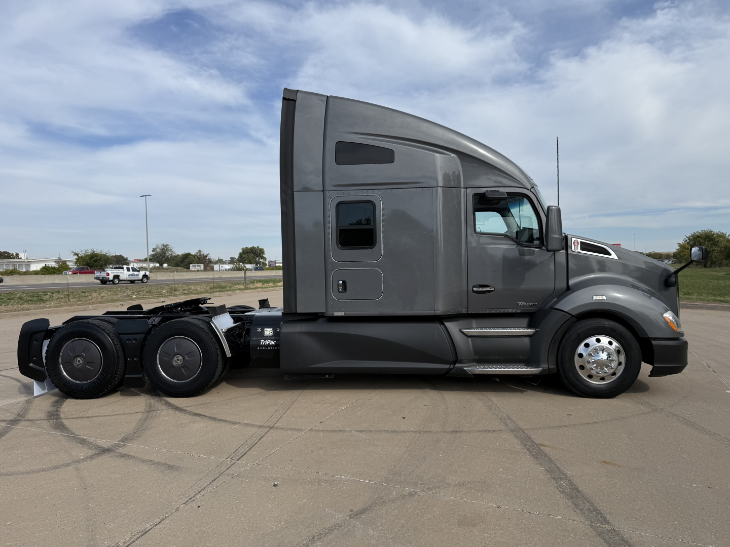 Kenworth T680 side view showing sleeper cab, rear wheels, and exterior panels.