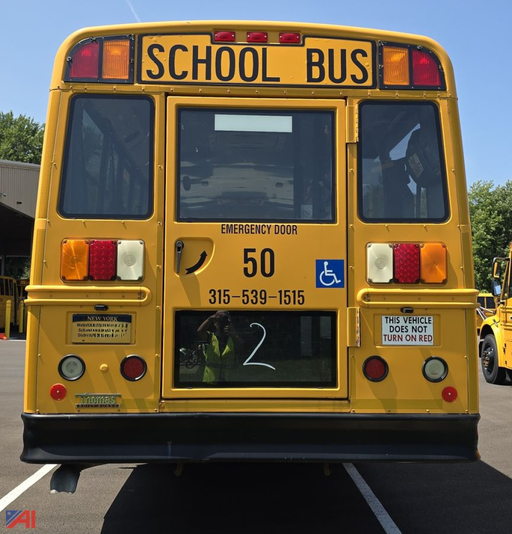 Rear view of a 2014 Freightliner Thomas B2B C2 school bus with wheelchair lift, showing emergency door, bus number 50, wheelchair accessibility symbol, and stickers.