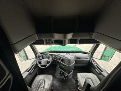 Volvo VNL64T760 cab interior showing steering wheel, dashboard, and driver and passenger seats.