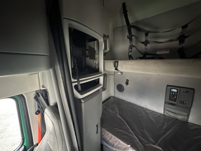 Volvo VNL64T760 sleeper cab interior showing storage cabinet and sleeper bunk area with controls panel.