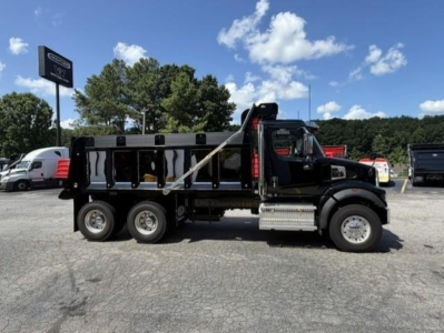 Western Star 47X dump truck side view showing black dump body, dual rear axles, and hydraulic lifting mechanism.