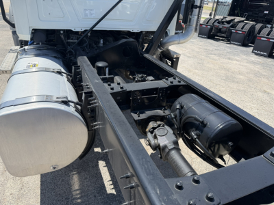 Truck chassis and fuel tank visible with drivetrain components, Mack GR64F cab and chassis layout showing frame rails, air lines, and cylindrical fuel tank.