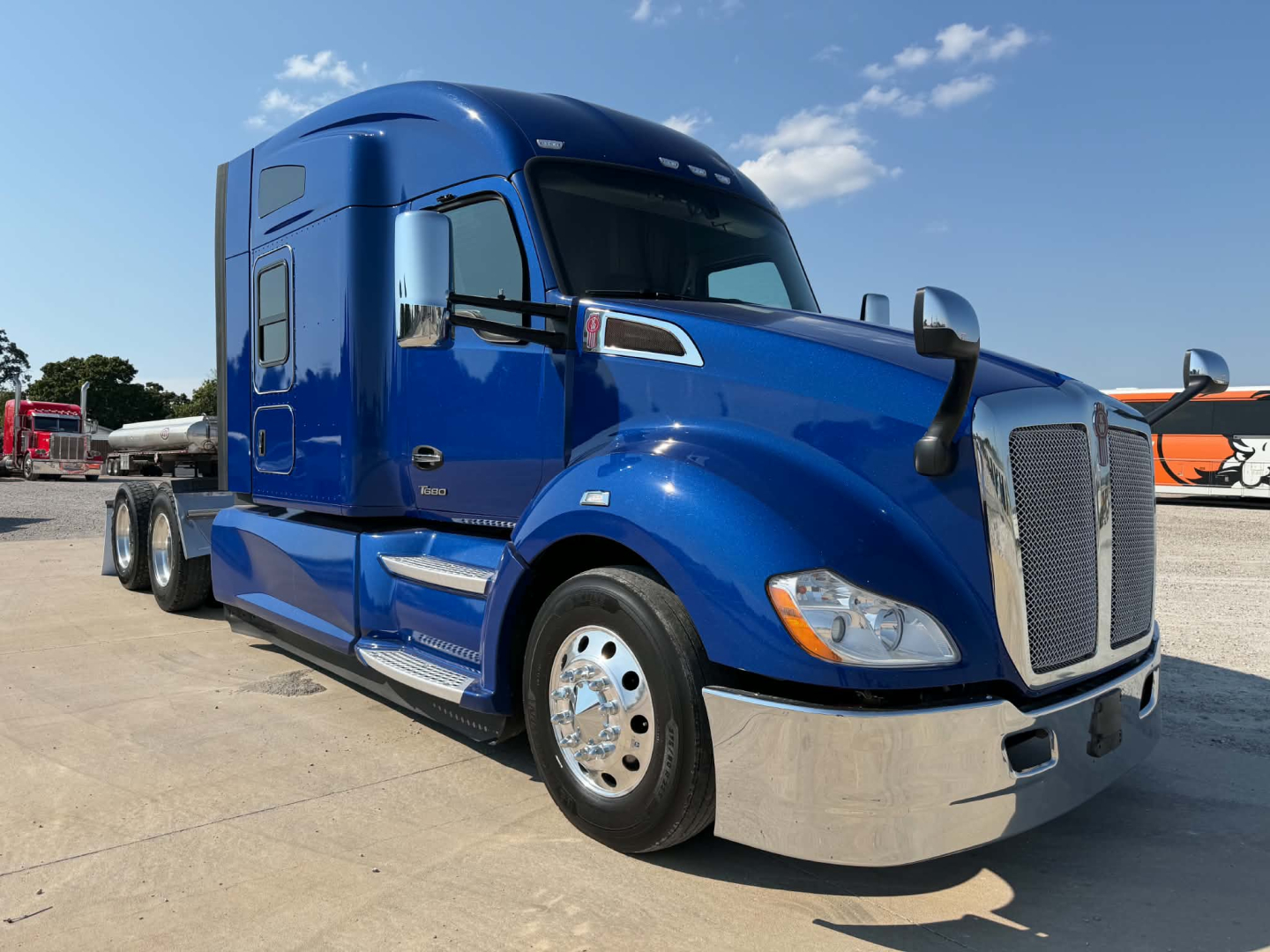 Kenworth T680 tractor-trailer in blue, front three-quarter view, with chrome bumper and dual mirrors.