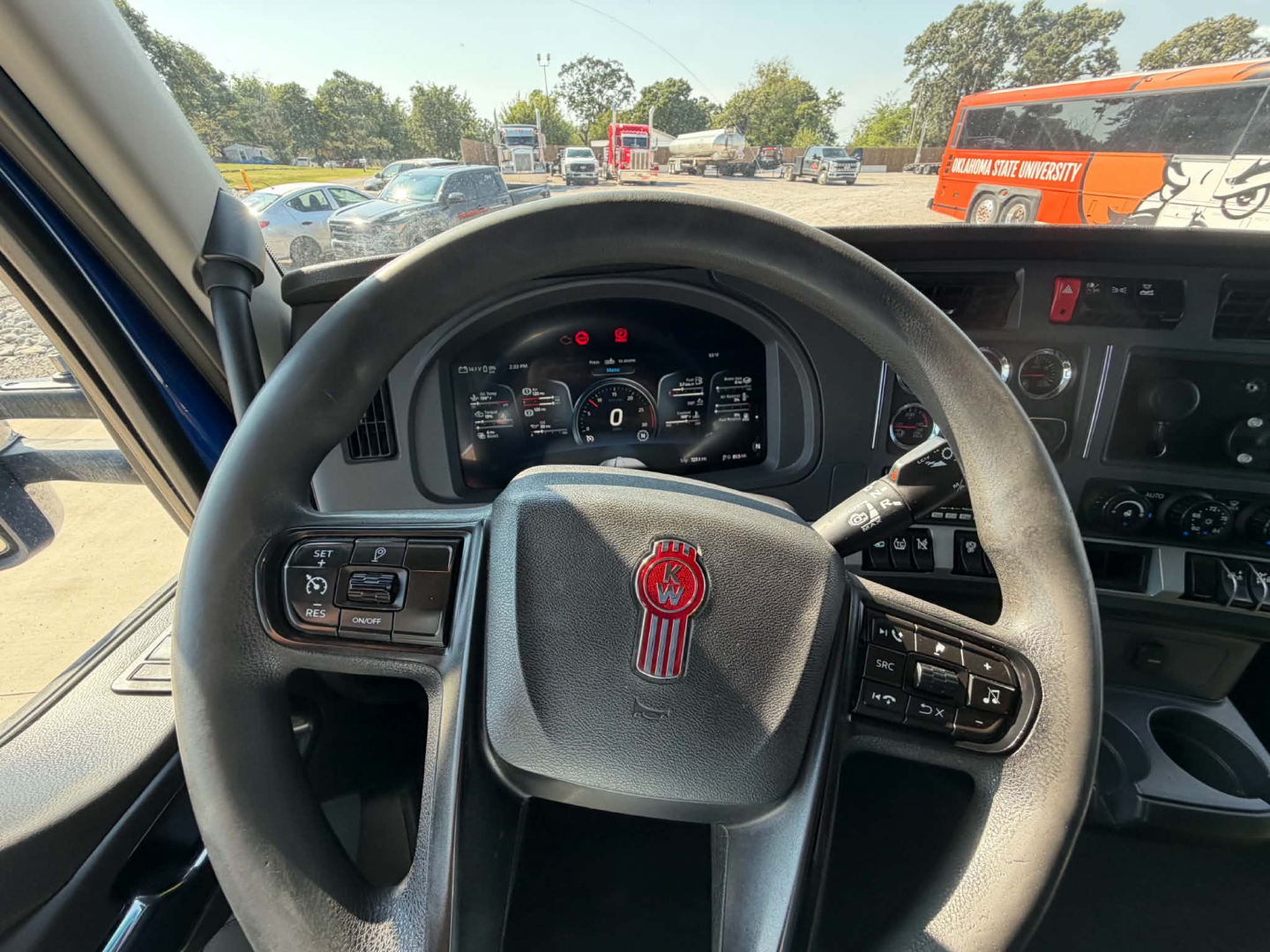 Kenworth T680 interior steering wheel and dashboard view from driver seat with digital instrument cluster.