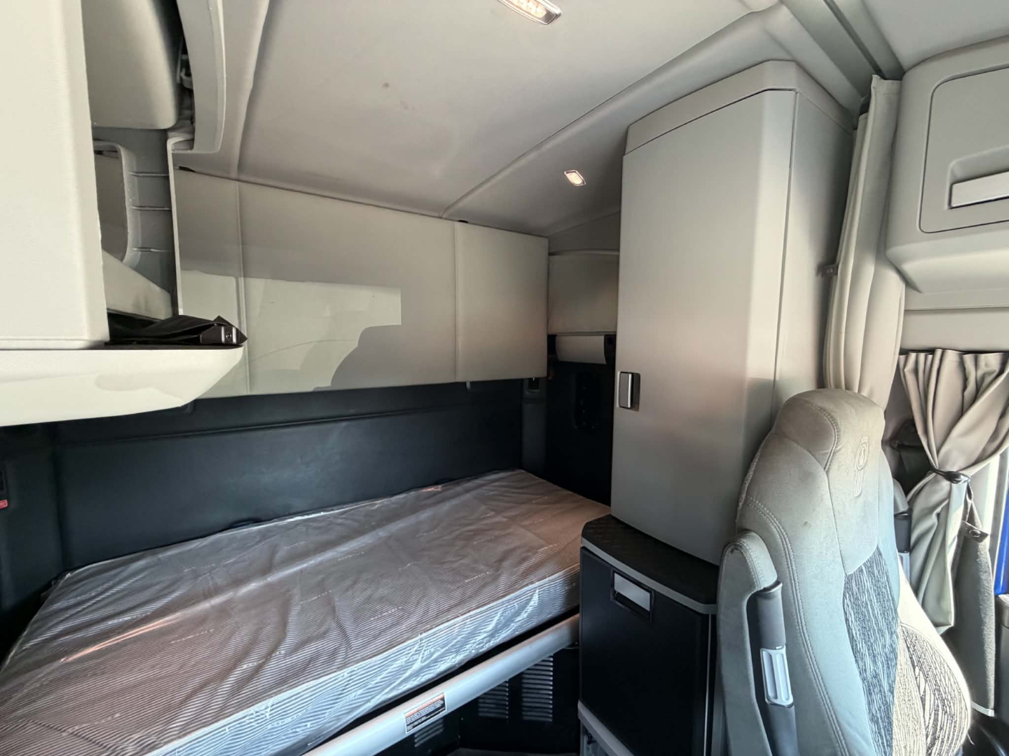 Kenworth T680 sleeper cab interior showing bunk bed and storage compartments