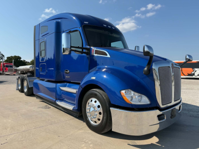 Kenworth T680 tractor-trailer in blue, front three-quarter view, with chrome bumper and dual mirrors.