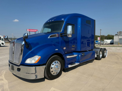 Blue 2022 Kenworth T680 truck side view showing front grille, headlights, and sleeper cab with chrome bumper and wheels.