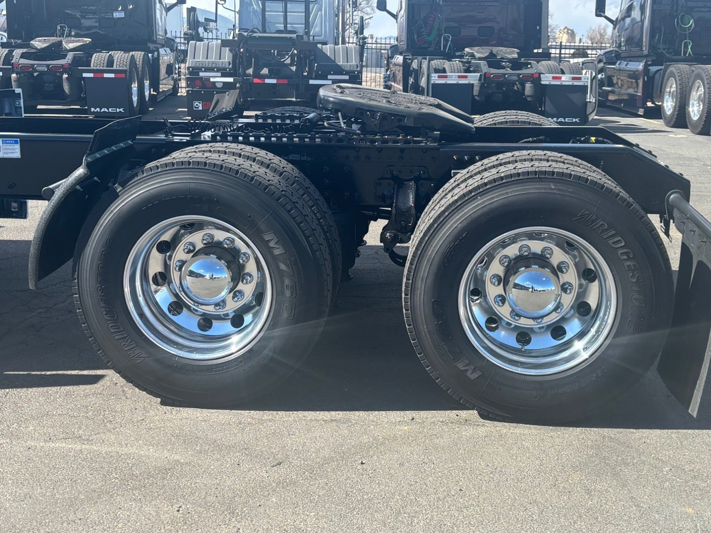 Mack PR64T76M chassis showing dual rear wheels and suspension, with metallic chrome wheels and black undercarriage.