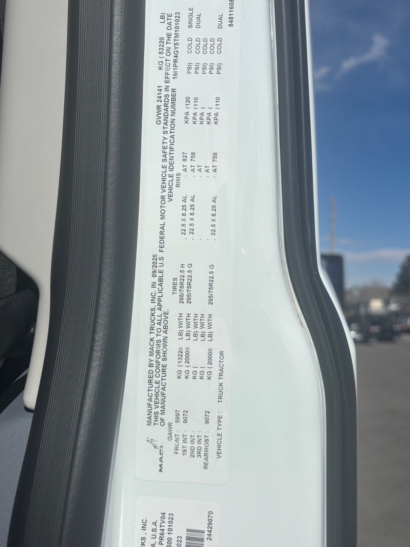 Label with vehicle specifications on Mack PR64T76M: GVWR, front axle, rear axle, tire size, engine, VIN partial, model. Text includes 1M1PR4GY5TM101023 and miscellaneous numbers.