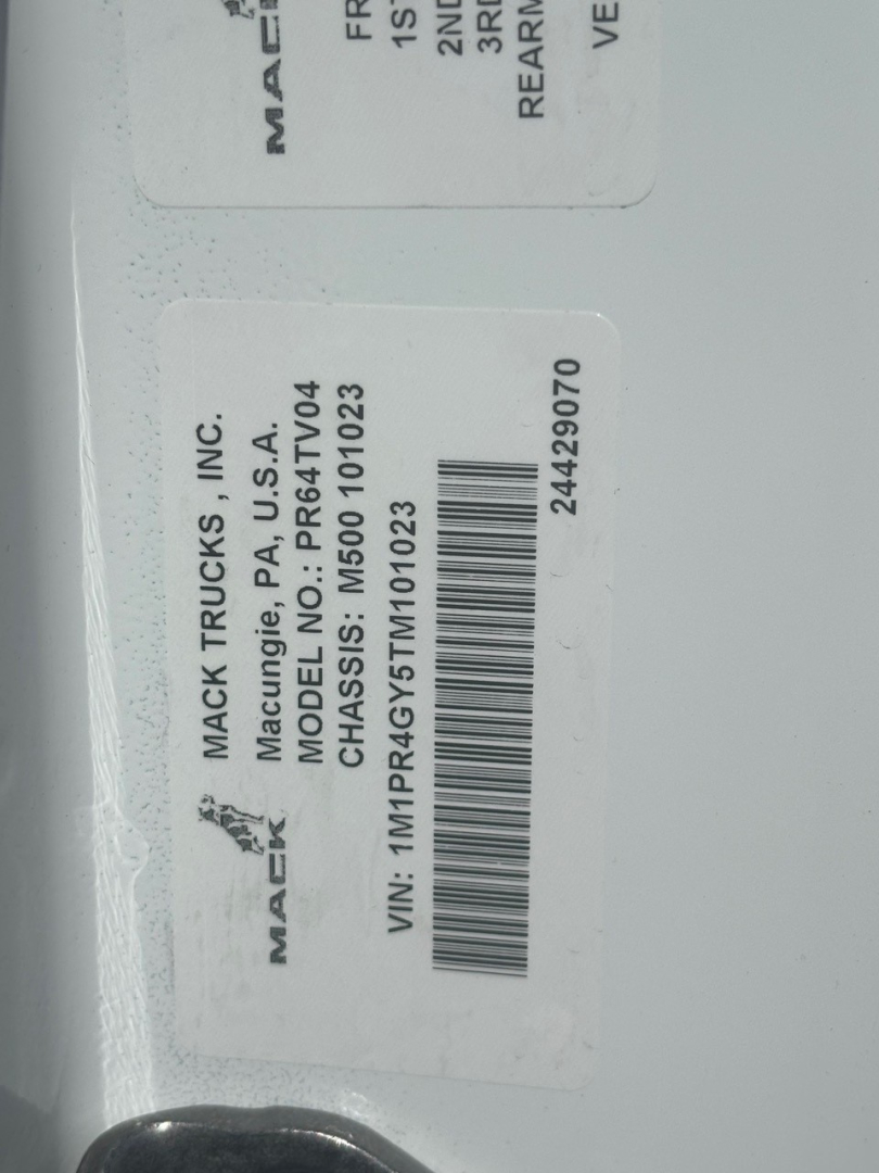 Mack Trucks label showing model PR64T04? with VIN barcode and tag text. Visible text includes MACK TRUCKS INC., MODEL PR64T04, CHASSIS NO. PR64T04, VIN: 1M1PR4GY5TM101023, 24429070, MACK TRUCKS MACON, USA
