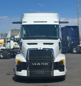 Front view of a white 2026 Mack PR64T76M truck cab with black grille and yellow daytime running lights.