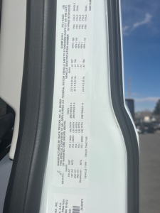 Label with vehicle specifications on Mack PR64T76M: GVWR, front axle, rear axle, tire size, engine, VIN partial, model. Text includes 1M1PR4GY5TM101023 and miscellaneous numbers.