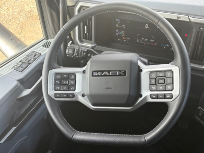 Mack PR64T76M truck interior steering wheel with control buttons and digital dash view.