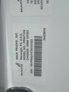 Mack Trucks label showing model PR64T04? with VIN barcode and tag text. Visible text includes MACK TRUCKS INC., MODEL PR64T04, CHASSIS NO. PR64T04, VIN: 1M1PR4GY5TM101023, 24429070, MACK TRUCKS MACON, USA