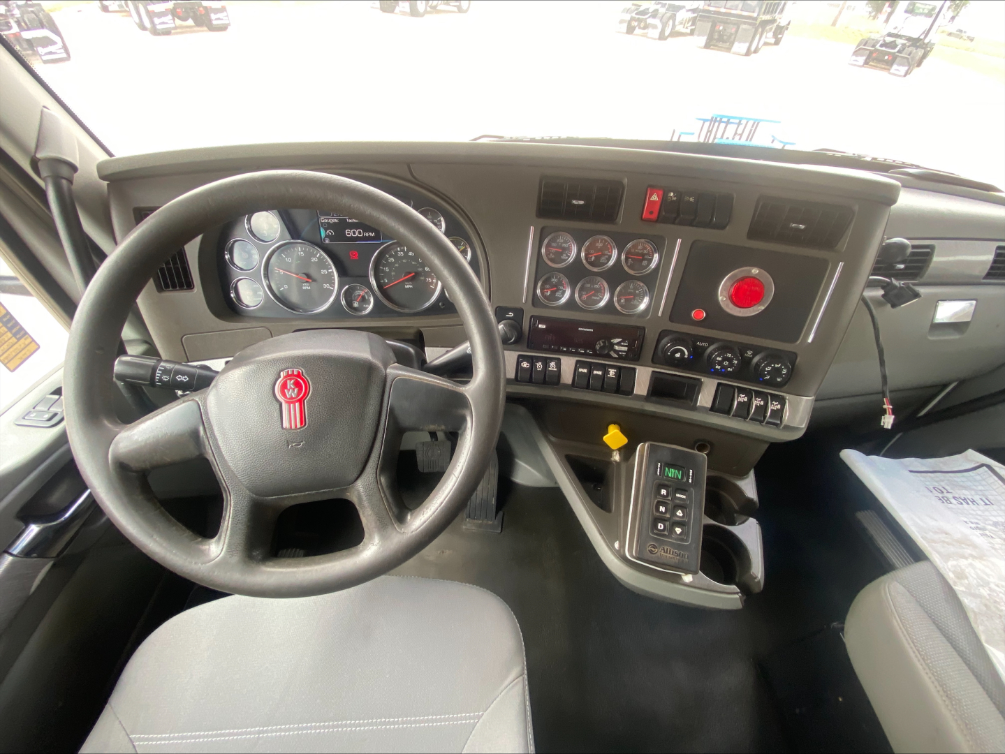 Kenworth T880 cabin dashboard and steering wheel with multiple gauges and controls visible.