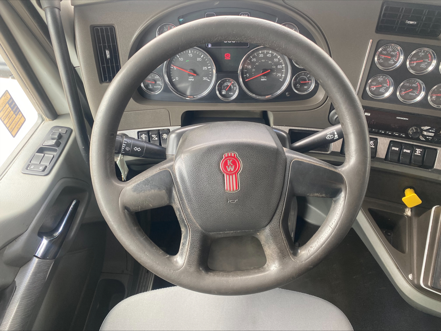 Kenworth T880 dashboard and steering wheel interior showing instrument cluster, steering wheel badge, and control panels.