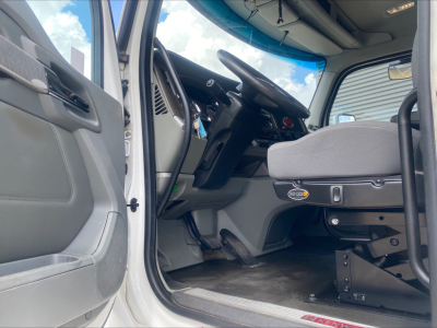 Kenworth T880 cab interior showing steering wheel, dashboard, and driver seat with control lever and door panel.