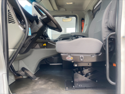 Kenworth T880 cab interior showing driver seat and controls in front of steering wheel.