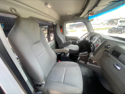 Kenworth T880 truck cab interior with grey cloth seats and dashboard; no visible text or labels readable in the photo.