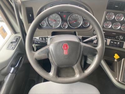 Kenworth T880 dashboard and steering wheel interior showing instrument cluster, steering wheel badge, and control panels.