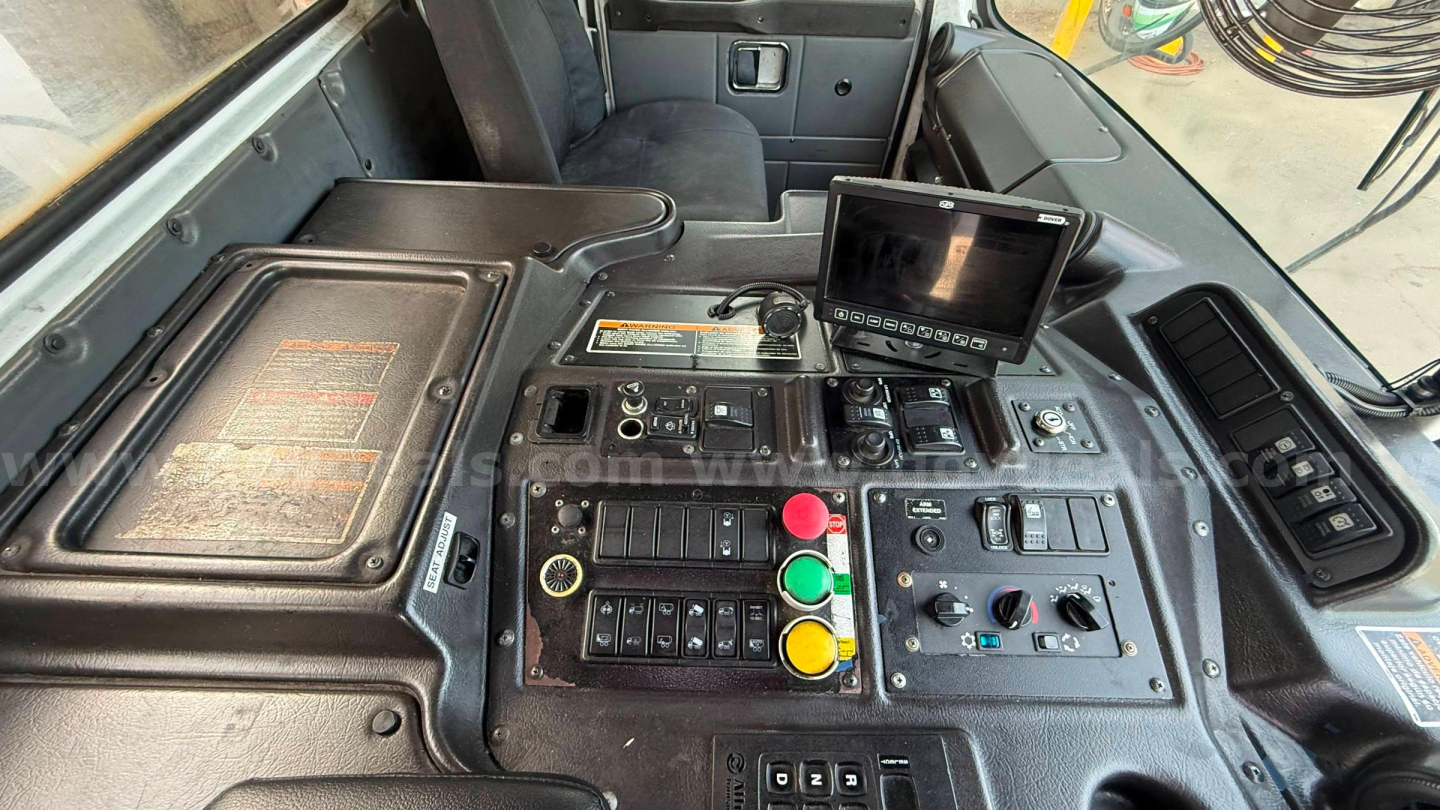 Autocar XPeditor cab control panel with multiple colored buttons and a small display screen.