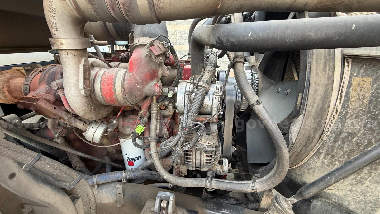 Engine bay of a 2016 Autocar Xpeditor truck showing turbocharger, hoses, alternator, and diesel engine components with grime residue.