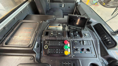 Autocar XPeditor cab control panel with multiple colored buttons and a small display screen.