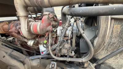 Engine bay of a 2016 Autocar Xpeditor truck showing turbocharger, hoses, alternator, and diesel engine components with grime residue.