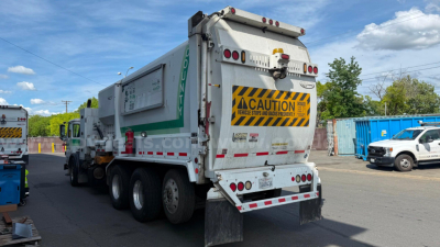 Autocar XPeditor garbage truck rear view showing caution sign and rear lights