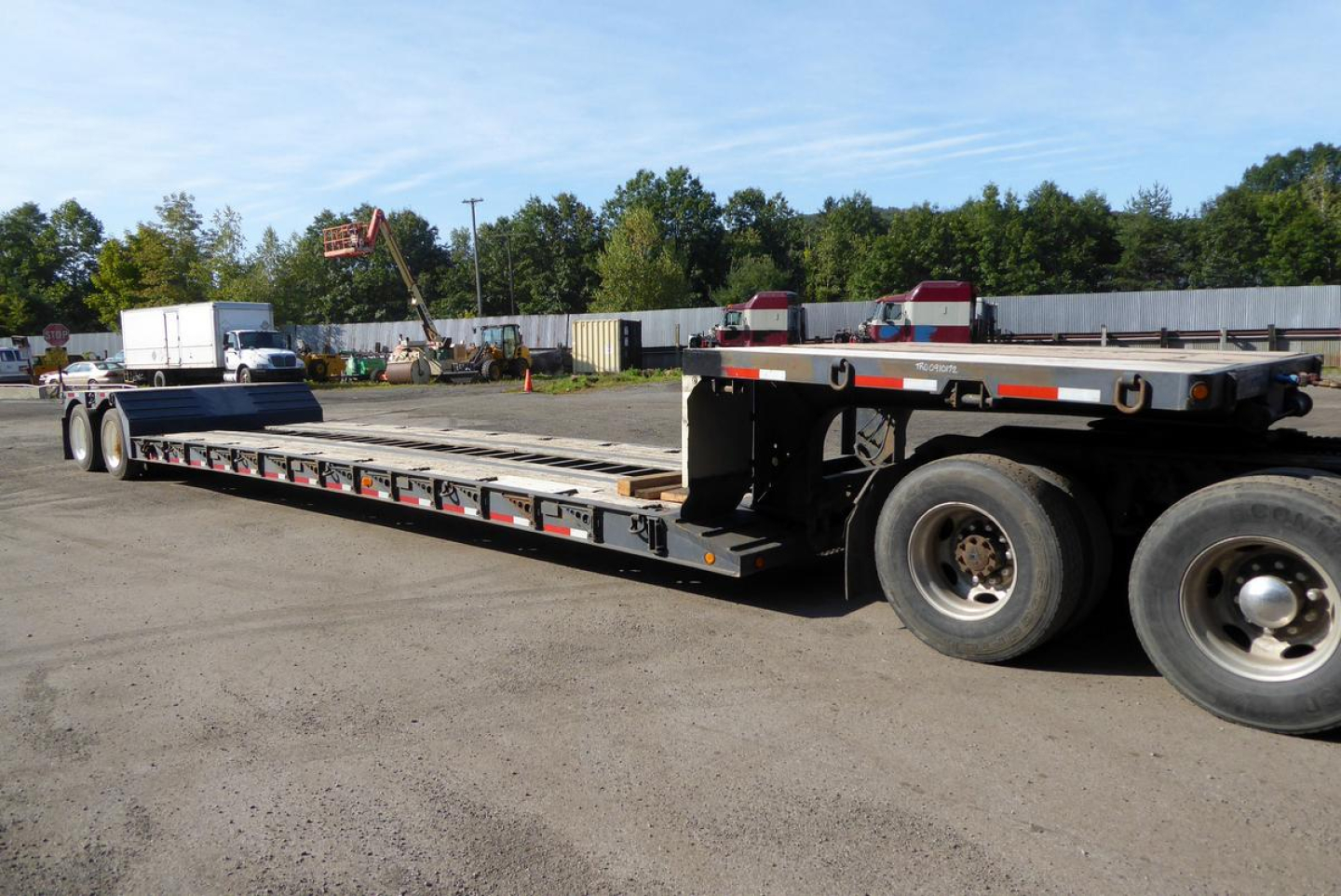 Fontaine 2002 lowboy trailer in side view showing long flatbed and dual rear axles with wheels