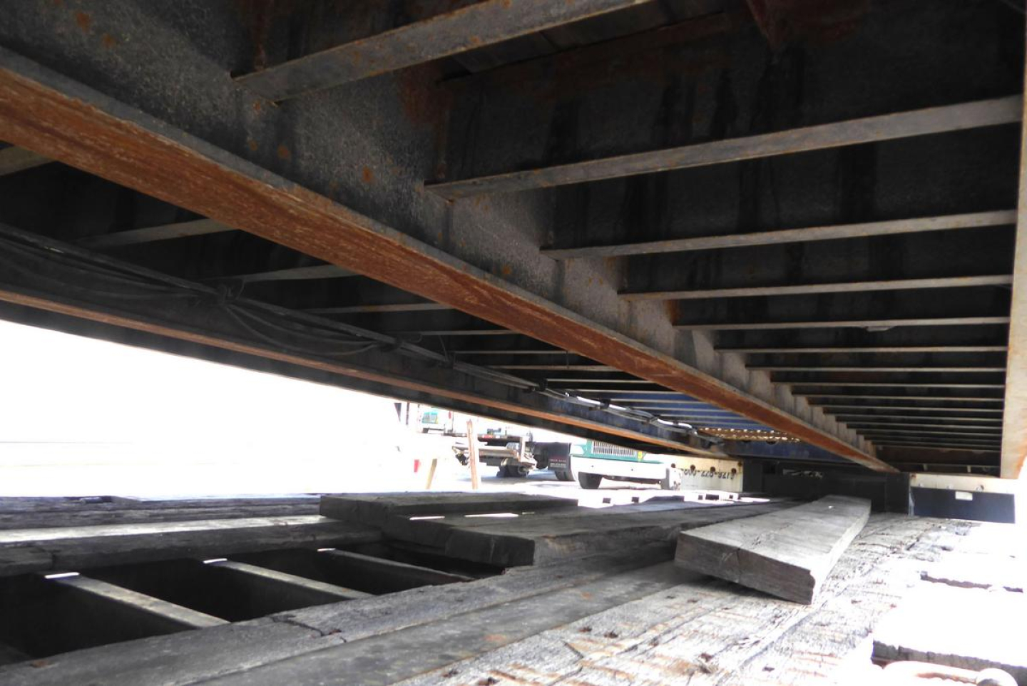 Trailer underside with deck beams and wooden planks visible under Fontaine 302WDMR-LT trailer
