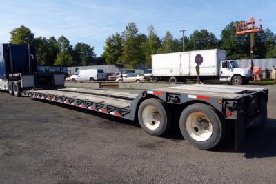  Fontaine 302WDMR-LT trailer in a parking lot showing long lowboy deck and dual rear axles with tires, stock number and VIN not visible in text.