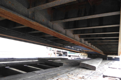 Trailer underside with deck beams and wooden planks visible under Fontaine 302WDMR-LT trailer