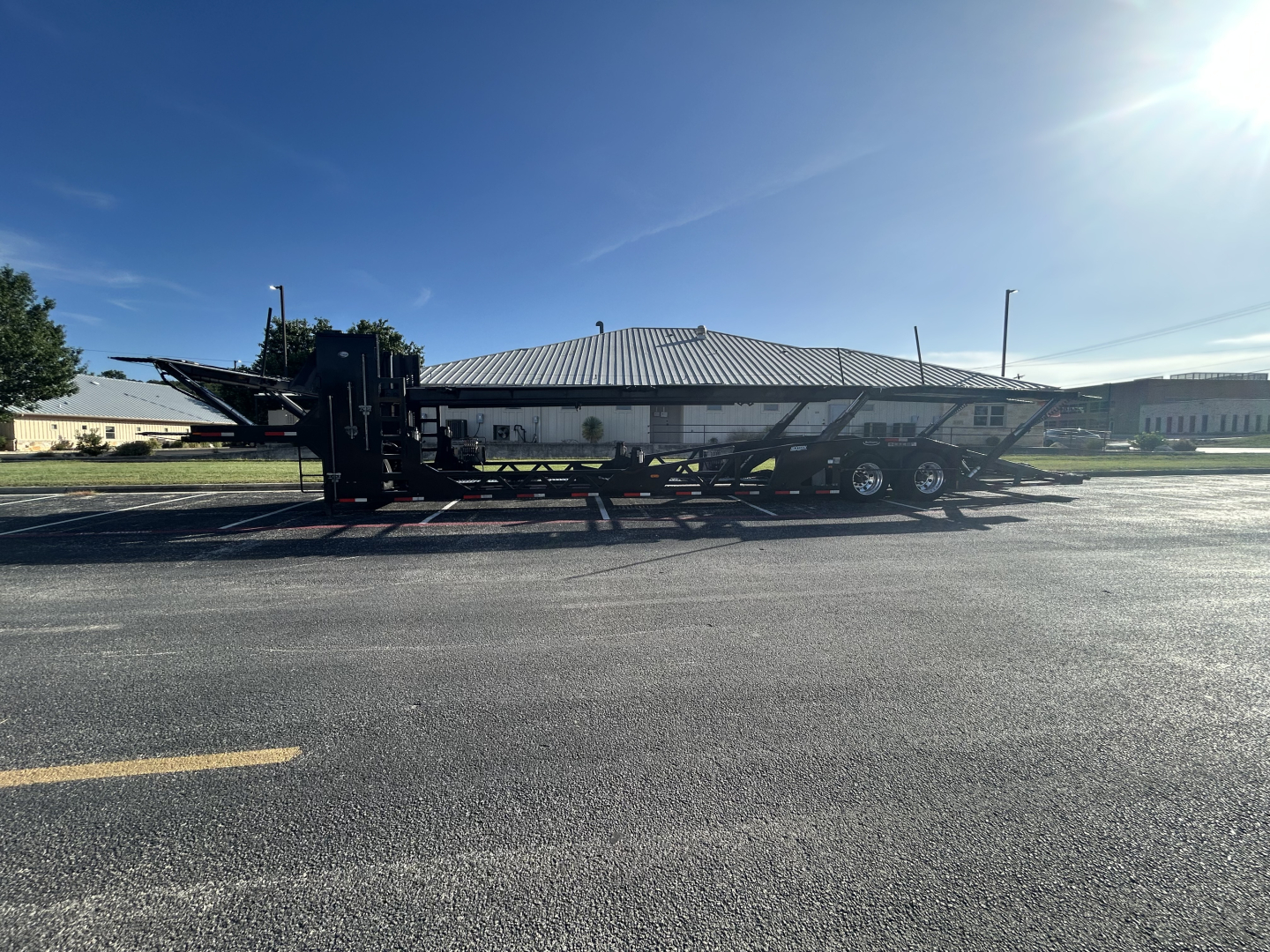 Cottrell CX-5308LT car carrier trailer side view showing multi-axle ramps and flatbed deck.