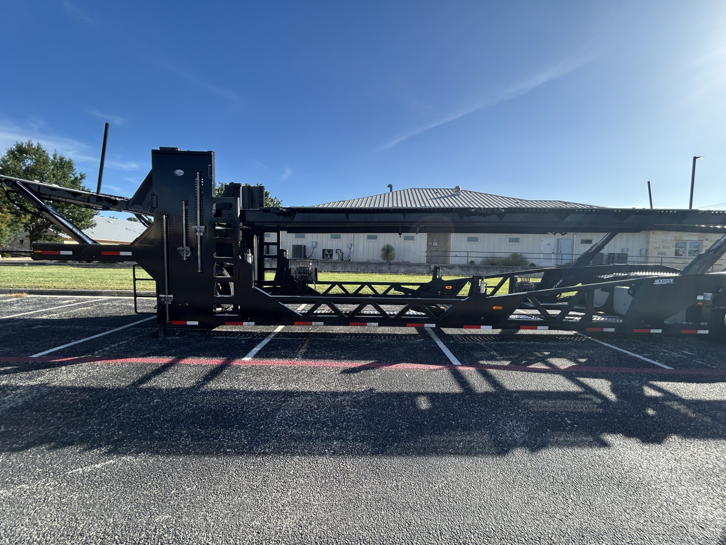 Trailer chassis of a 2022 Cottrell CX-5308LT car carrier trailer showing side profile with hydraulic equipment and lattice frame.