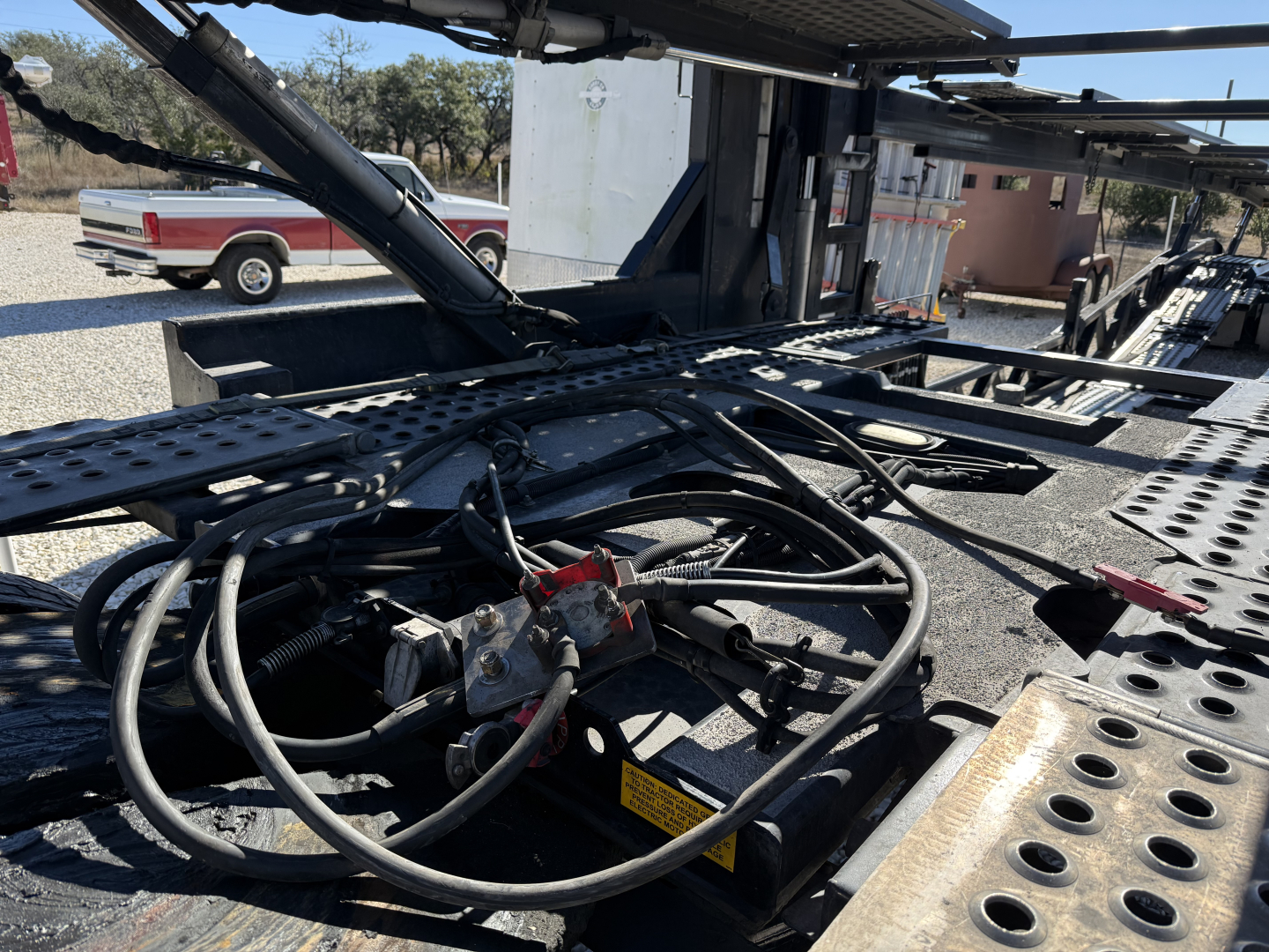 Trailer hydraulics and control lines on a 2022 Cottrell CX-5308LT car carrier trailer showing hoses, hydraulic components, and underframe.