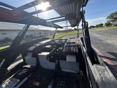 Interior of a 2022 Cottrell CX-5308LT car carrier trailer showing wheel area and undercarriage components with structural beams and hardware.