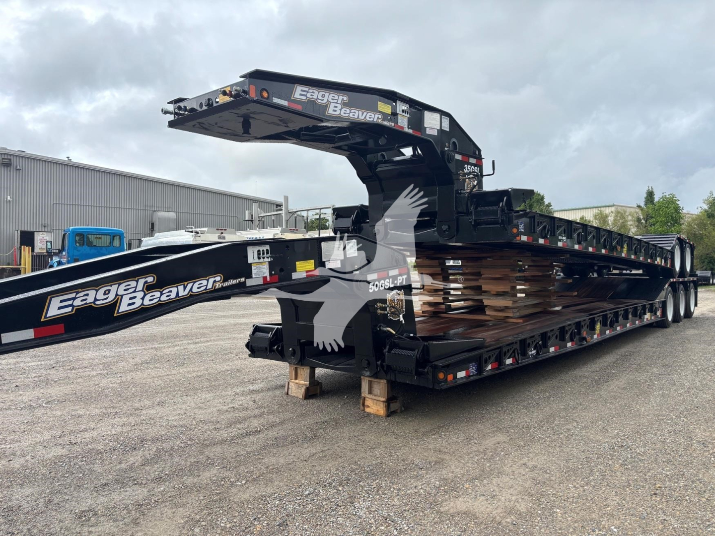 Eager Beaver 50Gsl-Pt trailer in a lowboy configuration with gooseneck arm, side rails, and multiple axles. Visible branding 'Eager Beaver' on the arm and deck.
