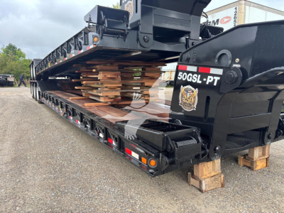Lowboy trailer showing stacked lumber on flatbed with hydraulic gooseneck, 50GSL-PT model plate visible on rear, VIN VL088761.