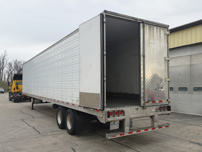 Great Dane Everest SS trailer side and rear showing open loading area and dual rear doors with diamond plate trim, aluminum siding, rear lights, and dual axle with tires.