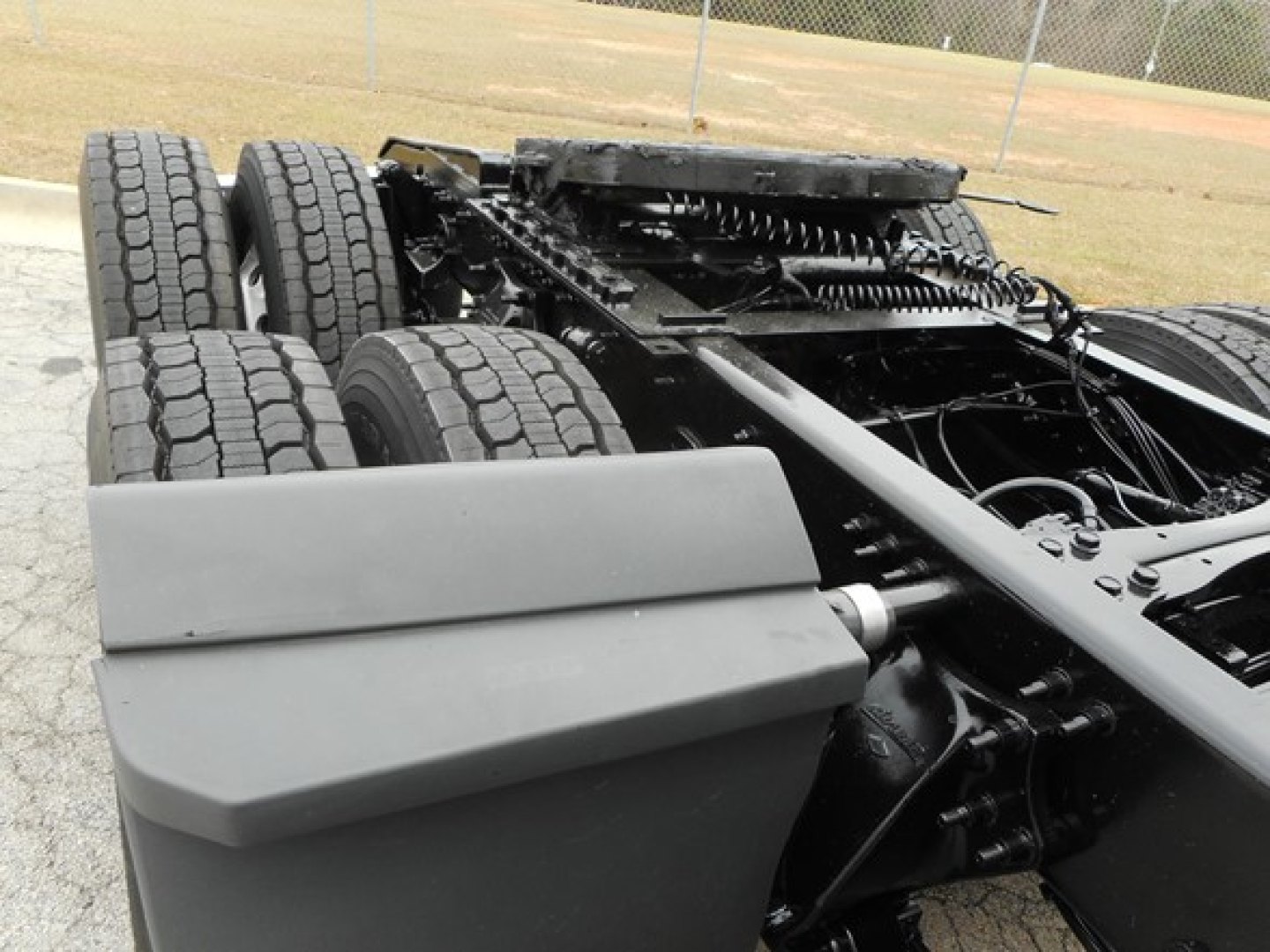 Freightliner Cascadia chassis and rear wheel assembly showing dual rear axles, frames, suspension, and fuel/air fluid compartments.