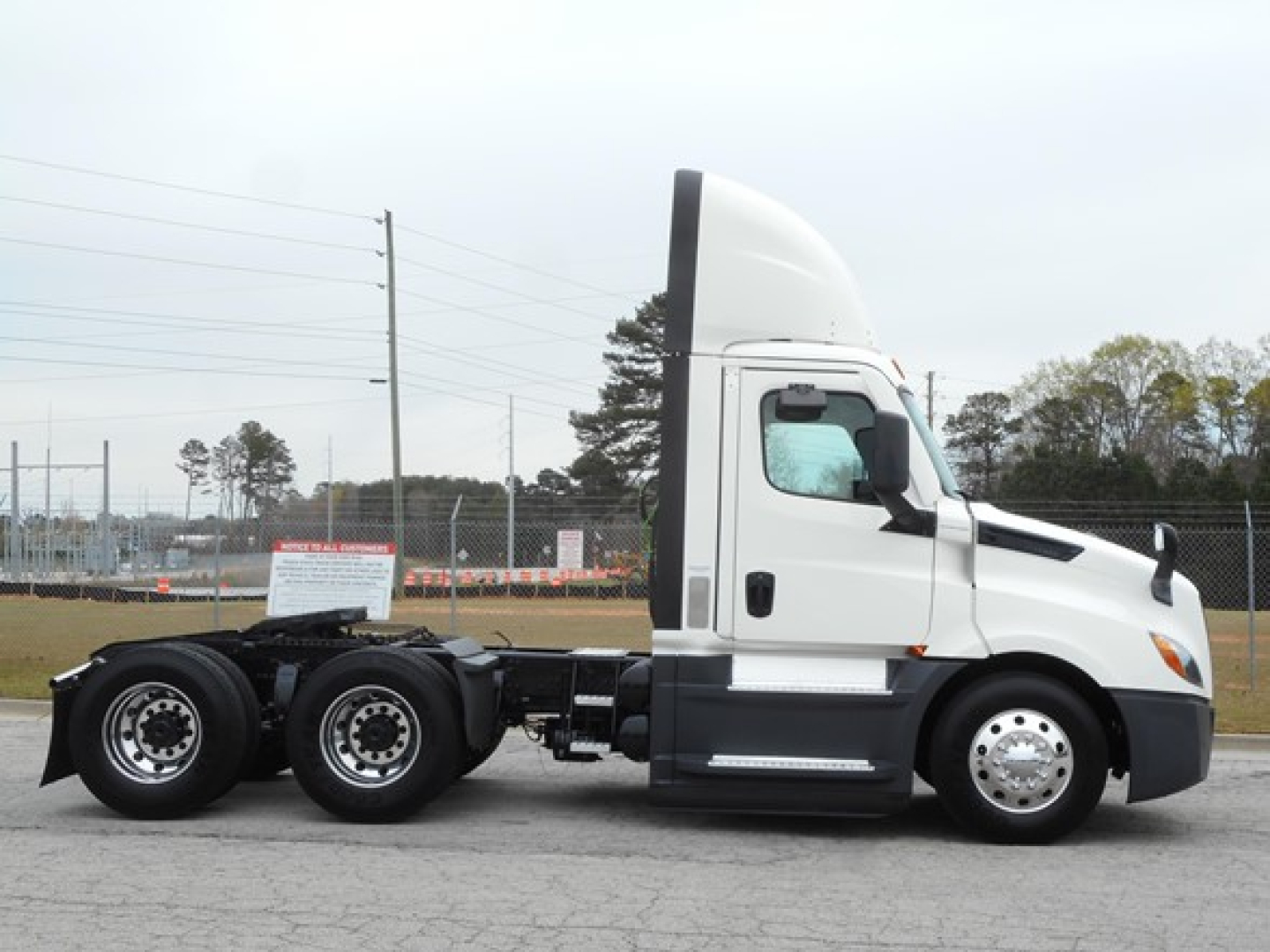 Truck side view showing 2021 Freightliner Cascadia 126 tractor with sleeper cab and dual rear axles.