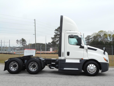 Truck side view showing 2021 Freightliner Cascadia 126 tractor with sleeper cab and dual rear axles.