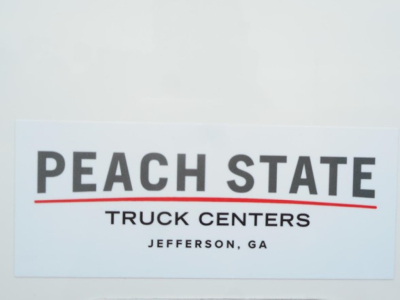 Peach State Truck Centers sign in the foreground with large bold letters, shows Jefferson, GA.