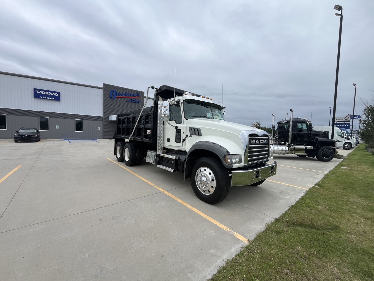 2020 Mack GR64F dump truck in a dealership lot showing cab and front grille with Mack logo.