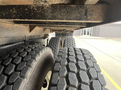 Mack GR64F dump truck rear axle wheels and undercarriage showing dual rear tires and underbody clearance.