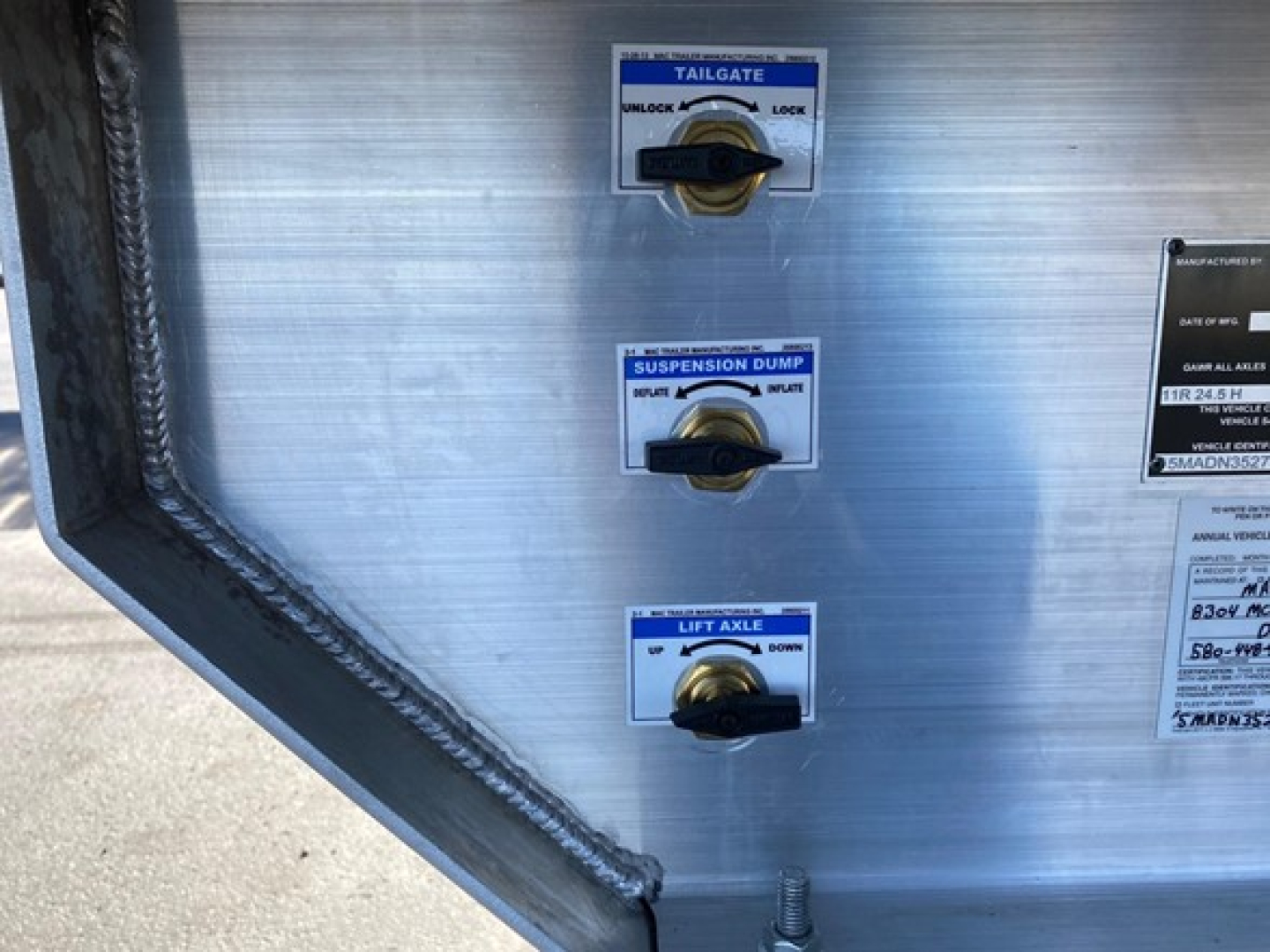 Trailer control panel showing tailgate, suspension dump, and lift axle controls with labels.